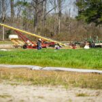 Rural farm scene in NC with machinery and a worker. Ideal for agriculture themes.